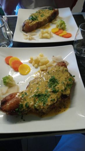 Assiette blanche de choucroute garnie avec saucisse, pommes de terre et carottes, vue de dessus.