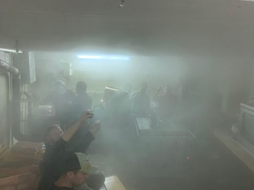 Une cuisine remplie de vapeur, des membres de l'amicale lèvent leur verre dans la buée