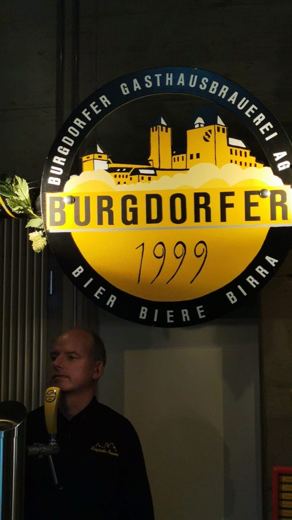 Enseigne lumineuse ronde de la brasserie Burgdorfer 1999, un homme debout devant un tireur à bière.