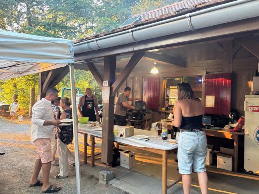 Le bar installé dans le refuge d'Ogens, deux personnes derrière le comptoir